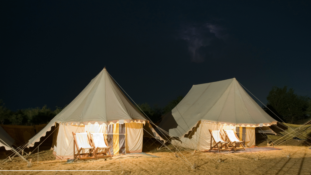 Luxury desert camping tents with modern amenities in Rajasthan safari camp at night