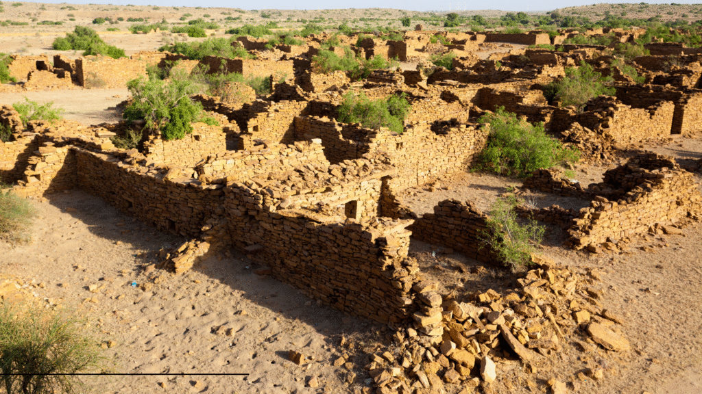 Crumbling gateway of Kuldhara Fort illuminated by soft twilight