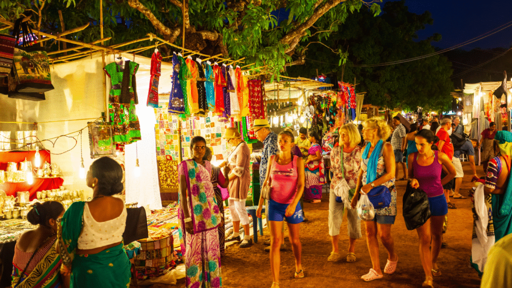 Anjuna Beach flea market at sunset with colorful stalls and a bohemian atmosphere.